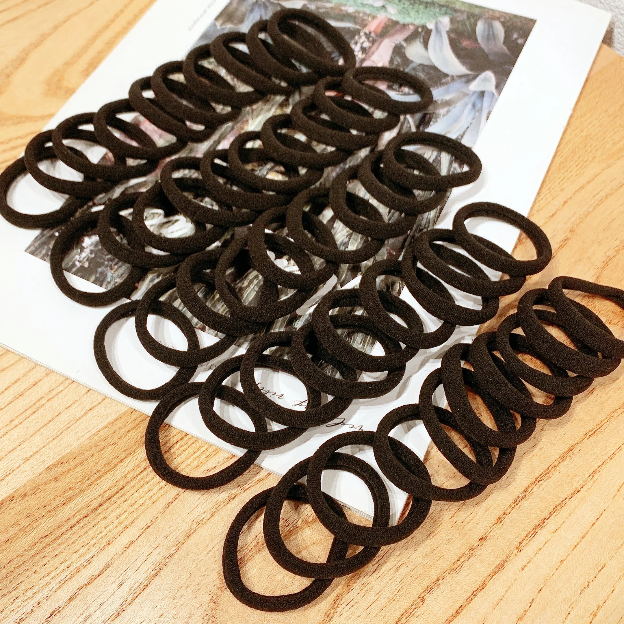 Kit com 50/100 Elásticos de Cabelo Pretos – Alta Elasticidade e Resistência para Coques, Rabos de Cavalo e Penteados do Dia a Dia